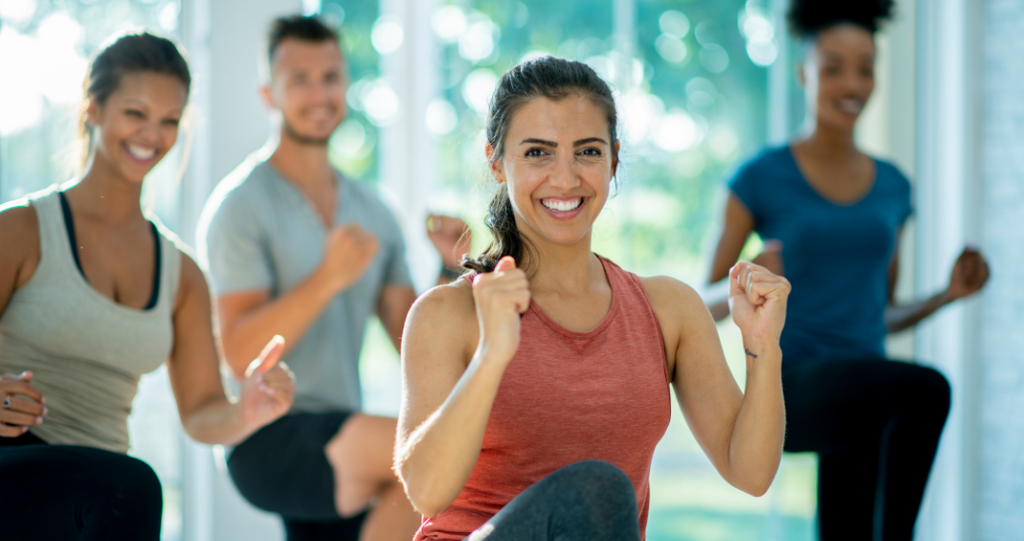 Four people joyfully participating in a group exercise class