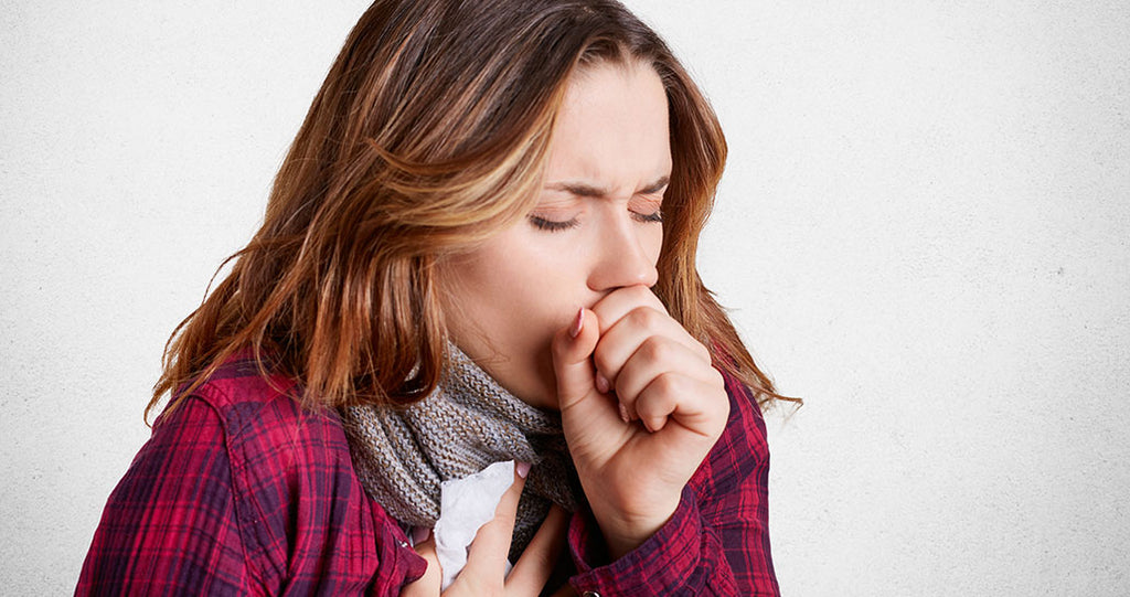Woman bundled up and coughing